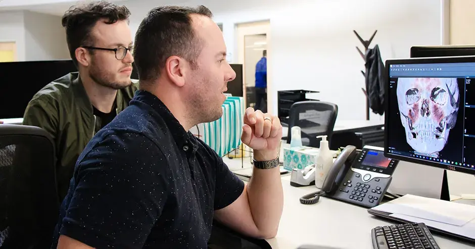 机に向かう 2 人の同僚