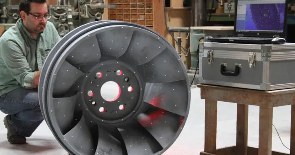 工場でインベストメント鋳造部品の隣に立っている人物