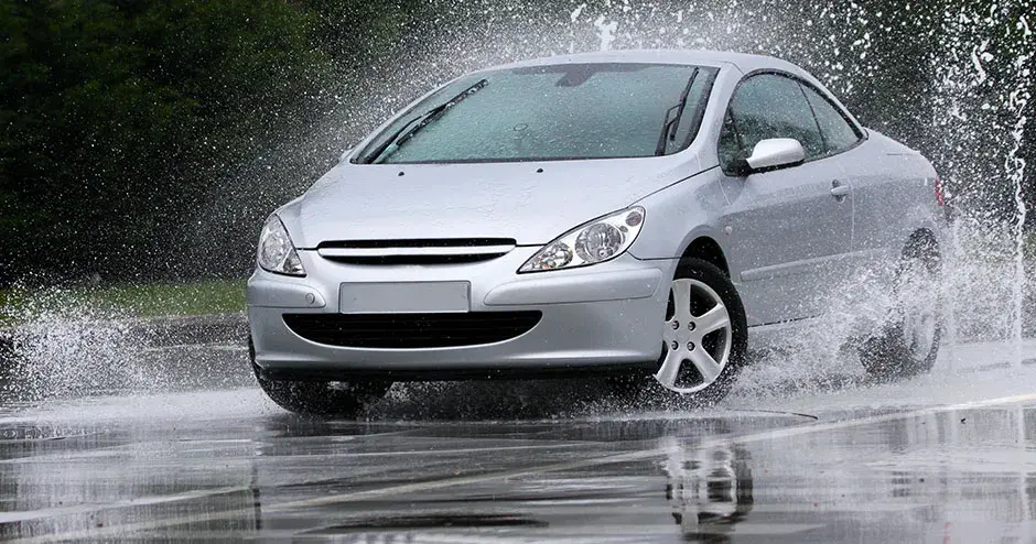 水たまりを走行し、大きな水しぶきを上げる車