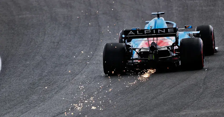 車体の後部から火花を散らしながらトラック上を走行する Alpine F1 レースカー