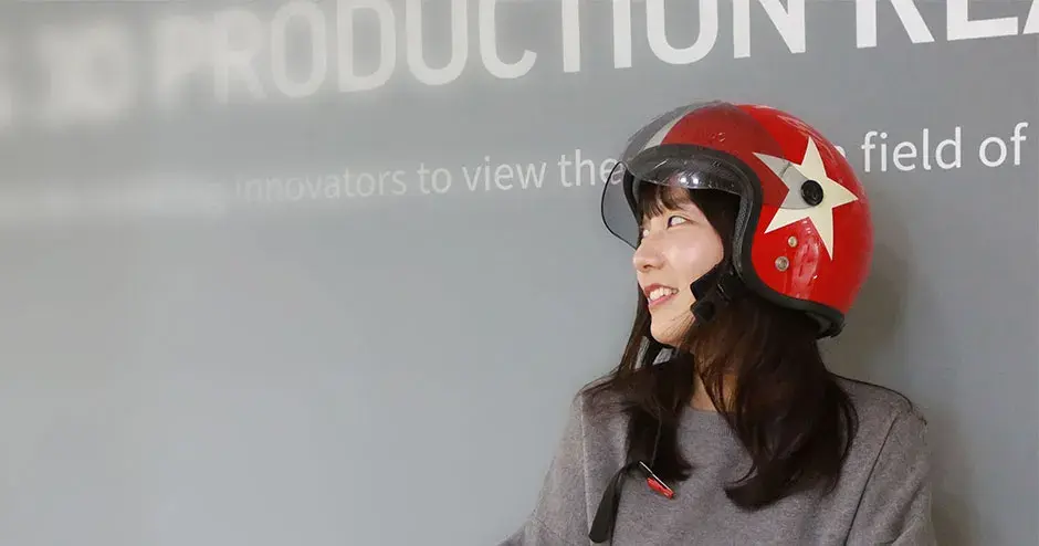 会社ロゴの横に立っている 3D Systems の従業員