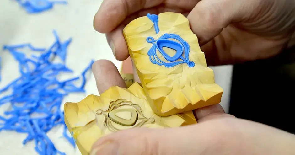 黄色のゴムモールドの中にある丸みがかった三角形のベゼルと、青色のワックスペンダント