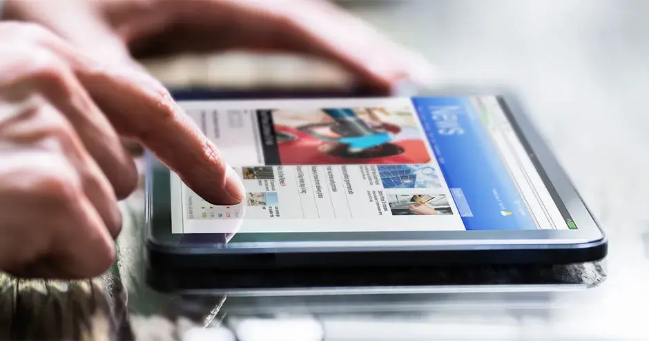 ハイライトされたニュースをタブレットで読んでいる人物