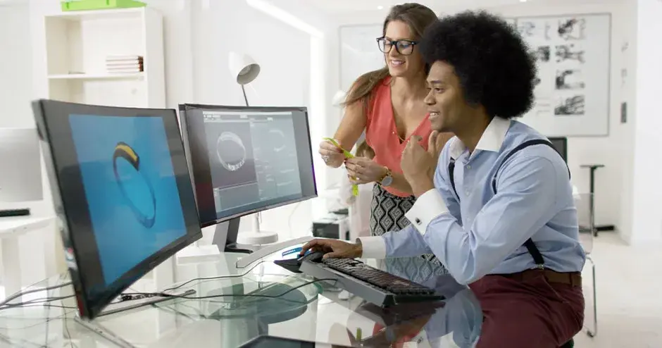 2 人で時計を設計し、大型モニタでファイルを編集している