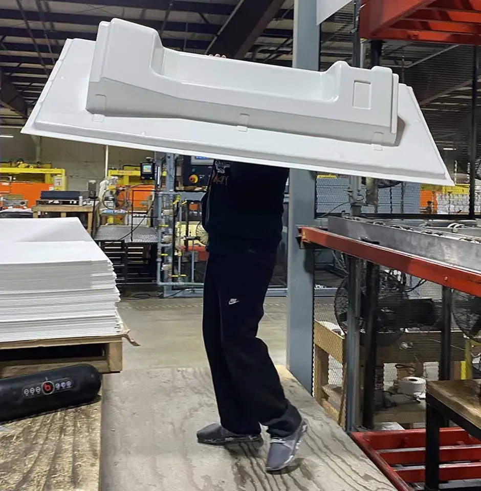 Duo Form 社の熱成形部品を運ぶ作業者