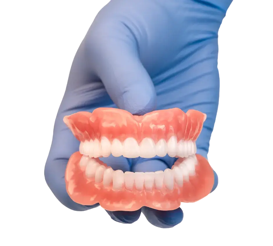 3D プリント義歯を見せている医療用手袋をはめた手