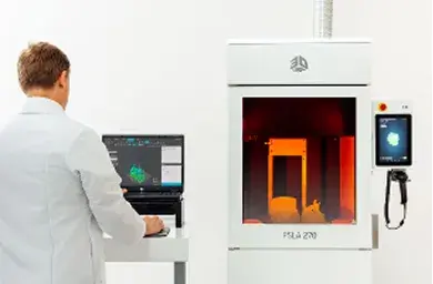 A man in a lab coat standing next to a 3D printer